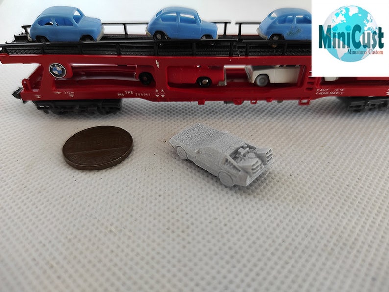 Puede incluir: Un coche modelo gris, que se asemeja a la m&aacute;quina del tiempo DeLorean de la pel&iacute;cula Regreso al futuro, est&aacute; sentado sobre una superficie blanca. El coche est&aacute; en una escala en miniatura y tiene un dise&ntilde;o detallado.