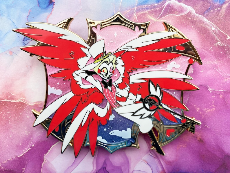 Op de afbeelding: Een kleurrijke emaille pin met een stripfiguur met rode en witte vleugels, een witte hoge hoed en een zwarte vlinderdas. De pin heeft een gouden rand en is geplaatst tegen een roze en paarse achtergrond. Het personage houdt een sleutel vast.