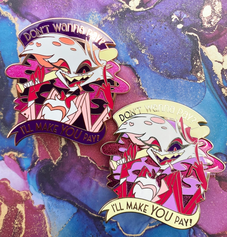 Op de afbeelding: Twee emaille pins met een cartoonfiguur met een wit gezicht, roze accenten en een rode middelvinger. De pins hebben de tekst "DON'T wanna pay?" en "I'LL MAKE YOU PAY!" op banners. De pins hebben een gouden omtrek.