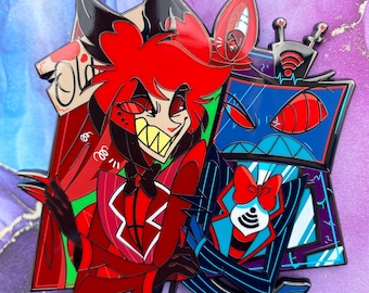 May include: A colorful enamel pin featuring two cartoon characters. One character is red with a wide grin, the other is blue with a TV screen head. The pin has a black outline and is set against a purple and white background.