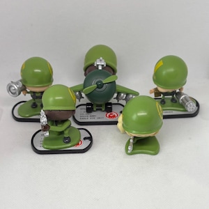 Puede incluir: Cinco soldados de juguete de plástico verde, uno de los cuales es un avión, con detalles amarillos. Los soldados sostienen armas y están de pie sobre una superficie blanca.