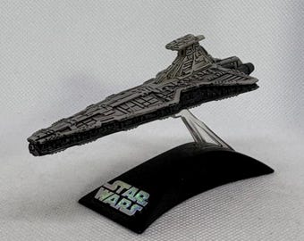 Miniatura em metal fundido do Cruzador de Ataque Imperial (Star Destroyer) da série Titanium de Star Wars da Hasbro com suporte de exibição.