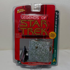 May include: A Johnny Lightning Legends of Star Trek Series Six Borg Cube die-cast collectible in original blister packaging. The red card features the Star Trek logo, text including Phasers Explosions Included, and a clear plastic bubble.