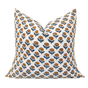 May include: A white pillow with a floral pattern in shades of orange and blue. The pillow is made of a soft, comfortable fabric and is perfect for adding a touch of color and style to any room.