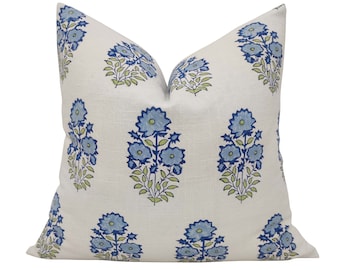 May include: A white cushion with a blue and green floral pattern. The cushion is made of a soft, textured fabric.