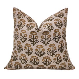 May include: A cream coloured pillow with a floral pattern. The flowers are a dark green and a light yellow colour.