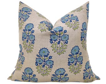 May include: A decorative throw pillow with a floral pattern. The pillow is made of a light beige linen fabric and features a repeating pattern of blue and green flowers.