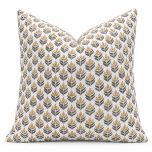 May include: A square throw pillow featuring a repeating pattern of stylized floral motifs. The design consists of yellow petals and dark gray stems and leaves arranged in vertical rows against a solid white background fabric.