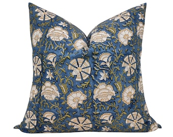 May include: A blue throw pillow with a floral pattern in shades of white, yellow, and green. The pillow is made of cotton and has a square shape.