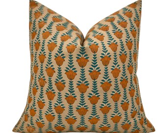 May include: A square throw pillow featuring a repeating vertical pattern of orange flowers with dark teal stems and leaves on a light beige background. The design consists of aligned rows of floral motifs arranged in a consistent, symmetrical grid.