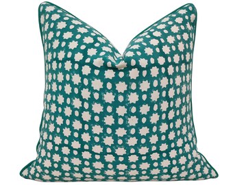 May include: Teal and white patterned throw pillow with a geometric design.