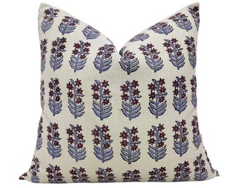 May include: A white pillow with a floral pattern in shades of purple and blue. The pillow is made of a soft, textured fabric and has a subtle sheen.