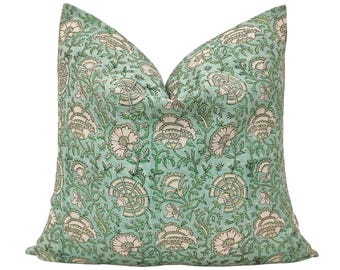 May include: A square decorative pillow with a floral pattern. The pillow features a light teal background with a repeating design of white and green flowers and foliage. The pillow is a soft, inviting accent for any room.