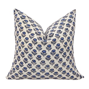 May include: A white cushion with a blue floral pattern. The cushion is made from a soft, comfortable fabric and has a subtle sheen.