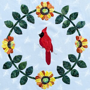 May include: A red cardinal bird perched on a branch with green leaves and yellow flowers. The flowers have a brown center and are surrounded by a ring of white petals. The background is a light blue.