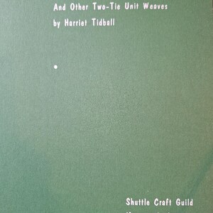 May include: A green book cover titled Summer and Winter And Other Two-Tie Unit Weaves by Harriet Tidball, published by Shuttle Craft Guild as Monograph Nineteen in 1966. The text is printed in white on a solid, matte green background.