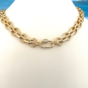 May include: A gold chain necklace with a double row of linked chain links and a small, round, pave-set clasp.