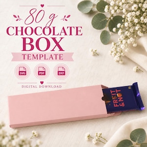 Pode incluir: Um modelo de caixa de papel rosa claro para uma barra de chocolate de 80 g. O texto diz 80 g CHOCOLATE BOX TEMPLATE, SVG, PDF, DXF e DIGITAL DOWNLOAD. Uma embalagem de chocolate azul escuro com o texto FRUIT & NUT está inserida.