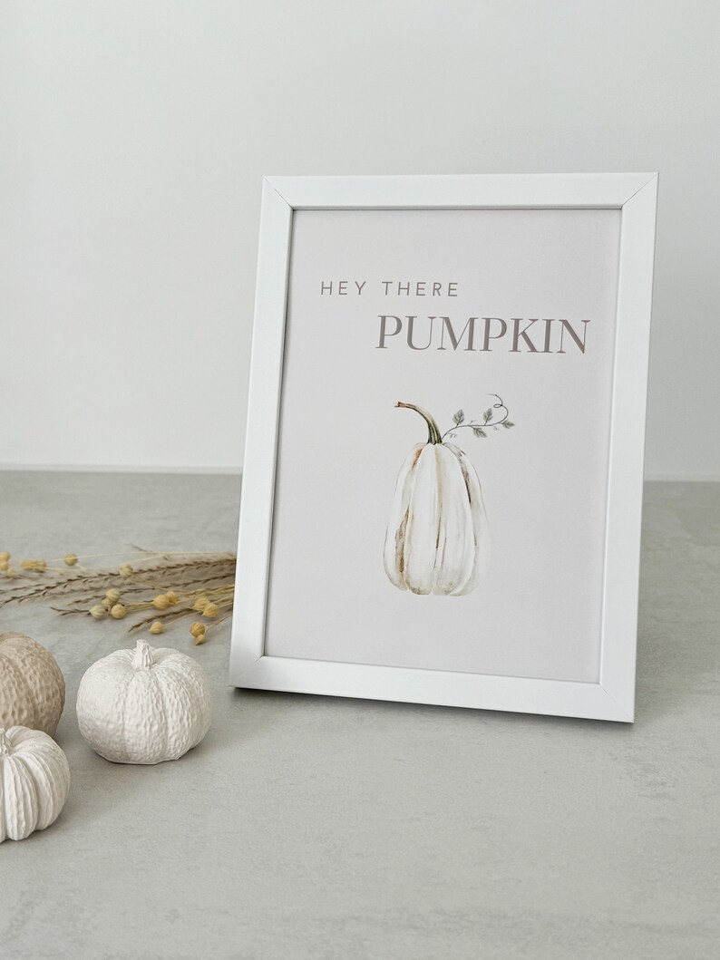 May include: White framed print with the text "Hey there Pumpkin" in brown lettering. A watercolor illustration of a white pumpkin with green leaves is in the center of the print.