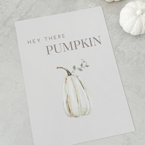 May include: A white printable sign with the text "Hey there pumpkin" and a watercolor illustration of a white pumpkin with green vines.