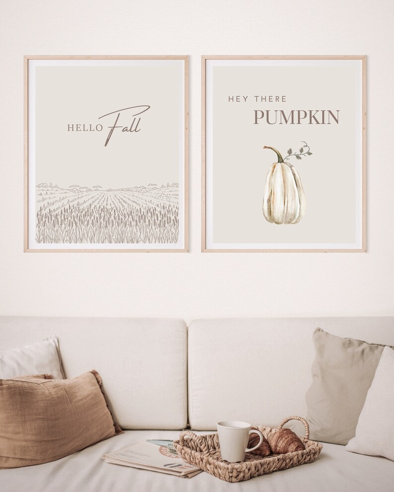 May include: Two framed prints with fall-themed designs. The left print features a field of wheat with the text "Hello Fall". The right print features a white pumpkin with the text "Hey There Pumpkin".