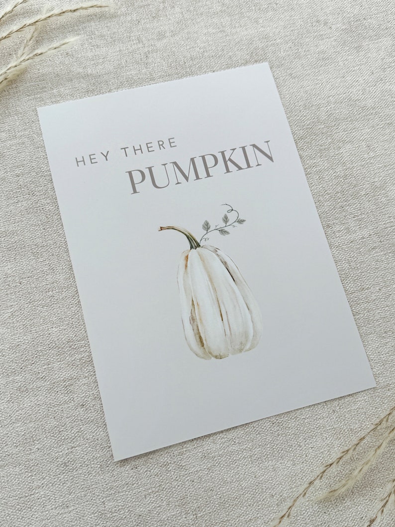 May include: A white printable sign with the text "Hey there pumpkin" in gray text. A watercolor illustration of a white pumpkin with a green stem and leaves is below the text.