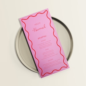 May include: Pink menu card with a red wavy border. The card says "Hello Hannah menu" and lists the entree, main, and dessert.