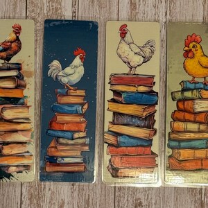 May include: Four bookmarks featuring colorful roosters perched atop stacks of vintage books. The bookmarks are made of metal and have a rustic, antique look.
