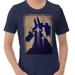 May include: Navy blue t-shirt featuring a framed graphic of a silhouette of a structure with multiple vertical elements and flying objects in a vintage style. The graphic is in shades of blue and tan.