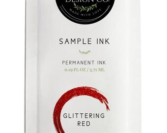 May include: A white sample ink packet with a black and green logo that says "Magnolia Design Co. Made with Love". The packet contains 0.19 fluid ounces of glittering red permanent ink.