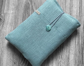 May include: A teal blue linen pouch with a button closure and a gray drawstring. The pouch has a small label that says "CASUALT" on it.