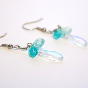 May include: A pair of silver dangle earrings with iridescent blue and clear glass beads.
