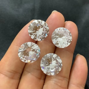 May include: Four clear round faceted rhinestones, each with a diameter of approximately 1 inch.