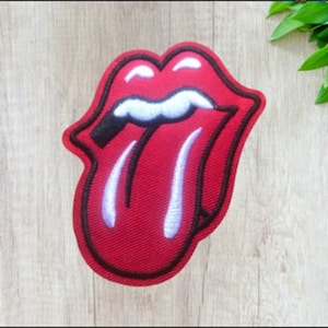 May include: Red and white embroidered patch of a tongue sticking out with a black outline.
