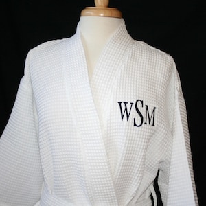 May include: White waffle weave robe with a navy blue monogram "WSM" embroidered on the chest.