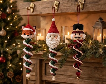 May include: Three crocheted Christmas ornaments hanging from gold hooks. The left is a fox in a Santa hat, the center is Santa Claus, and the right is a nutcracker. Each features a long, spiraling tail in red, green, and white yarn colors.
