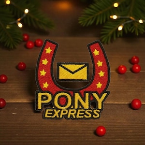 May include: Embroidered patch featuring a red horseshoe shape with yellow stars and the words "PONY EXPRESS" in yellow. A yellow envelope is in the center. The patch is on a wooden surface with red berries and greenery.
