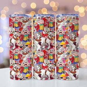 May include: Three stainless steel tumblers with a wrap-around design featuring cartoon characters in red, yellow, and blue. The design includes a frog in a red coat and a white horse. The tumblers are on a white surface.