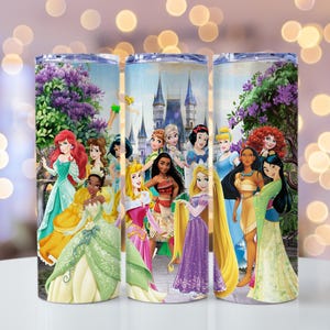 May include: A set of three stainless steel tumblers featuring a colorful illustration of Disney princesses. The design includes Ariel, Cinderella, Belle, and others, set against a backdrop of a castle and floral elements.