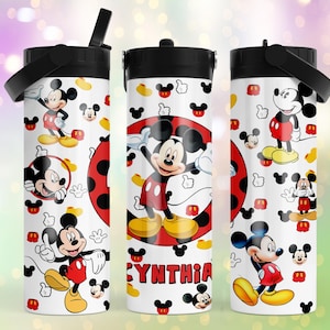 May include: A white cylindrical tumbler with a black lid and handle, featuring a repeating pattern of Mickey Mouse in red shorts and yellow shoes, along with small Mickey head icons and the name CYNTHIA printed in red block letters on the front.