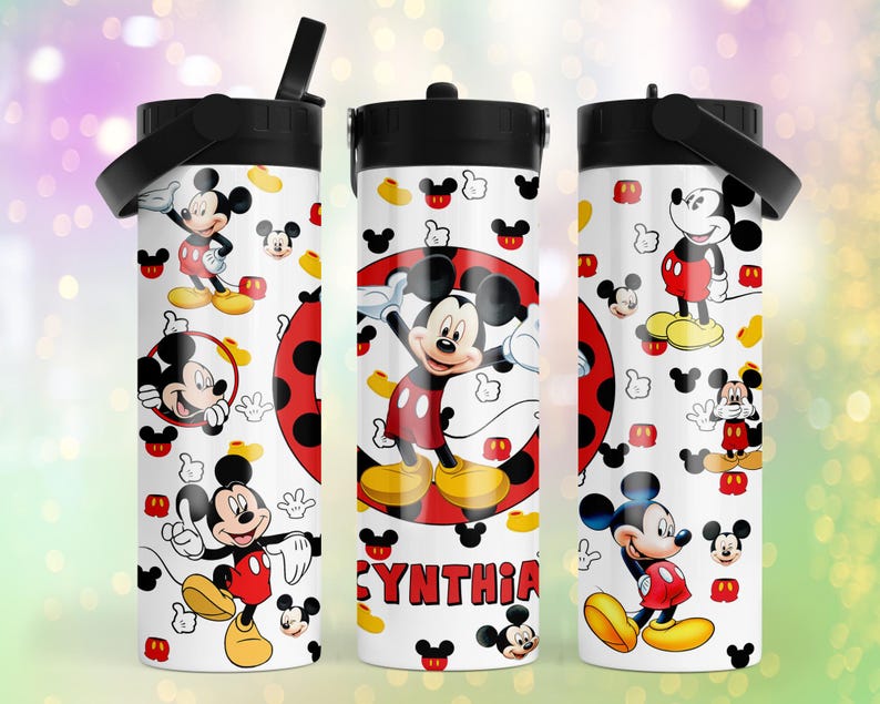 May include: A white cylindrical tumbler with a black lid and handle, featuring a repeating pattern of Mickey Mouse in red shorts and yellow shoes, along with small Mickey head icons and the name CYNTHIA printed in red block letters on the front.