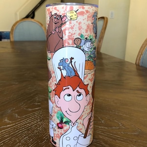 May include: A stainless steel tumbler with a colorful design featuring characters from the animated film Ratatouille. The design includes Remy the rat, Linguini, and other characters from the film. The tumbler is a great way to show your love for the movie.