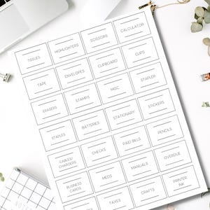 Könnte beinhalten: Ein weißes Blatt Papier mit schwarzen Etiketten für Büroartikel, darunter "Taschentücher", "Textmarker", "Schere" und "Taschenrechner". Die Etiketten sind in einem Raster angeordnet.