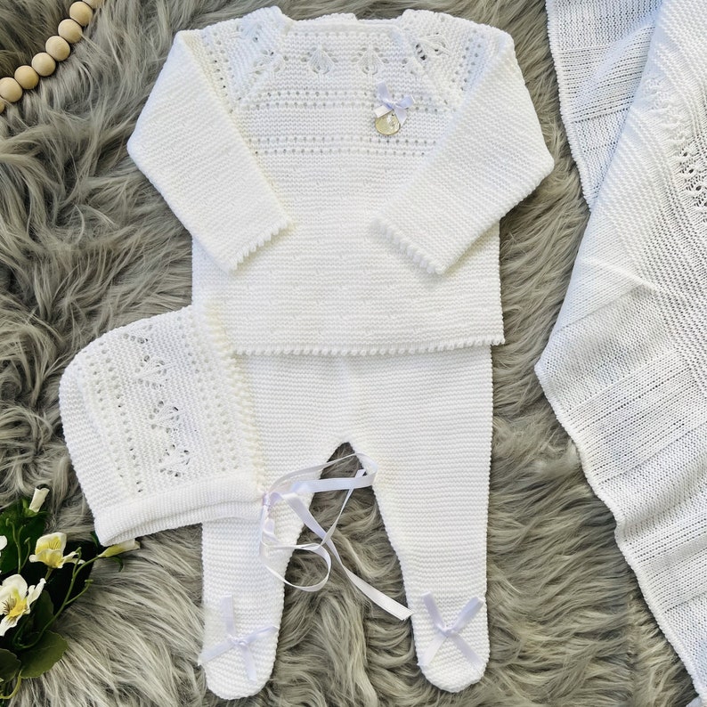 A lovely three-piece knitted set for babies with a sweater, bonnet, and pants. Suitable for baptisms, baby shower gifts, or bringing your newborn home from the hospital. It also can be purchased with a matching knitted blanket.