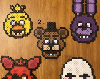 May include: Five different pixel art characters from the video game Five Nights at Freddy's. The characters are Freddy Fazbear, Bonnie the Bunny, Chica the Chicken, Foxy the Pirate Fox, and the Puppet. Each character is made of colorful plastic beads.