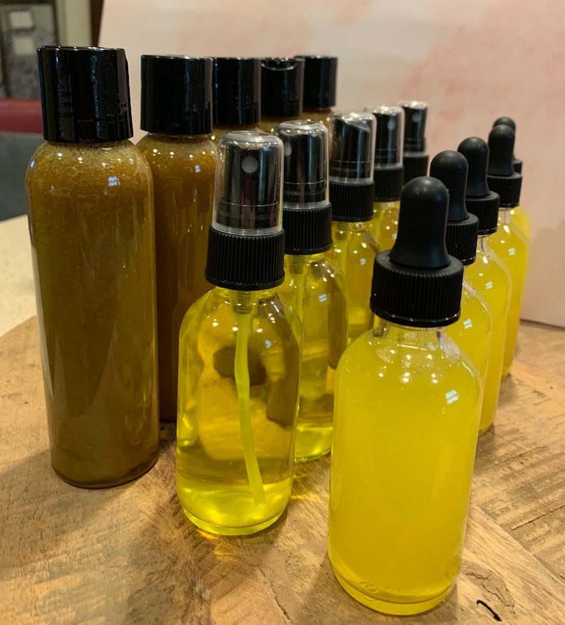 May include: A collection of amber and yellow glass bottles with black lids. Some bottles have a spray nozzle, while others have a dropper.