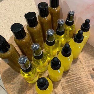 May include: A collection of amber and yellow glass bottles with dropper and spray tops. The bottles are arranged on a wooden surface.