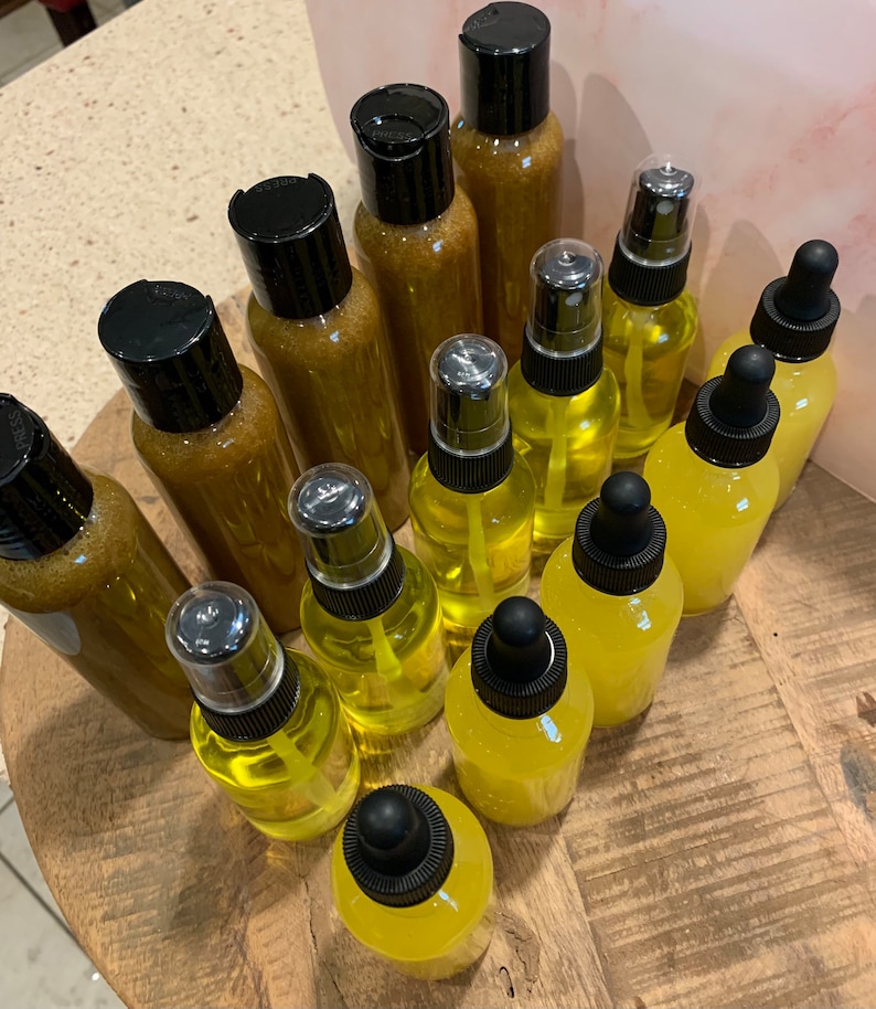 May include: A collection of amber and yellow glass bottles with dropper and spray tops. The bottles are arranged on a wooden surface.
