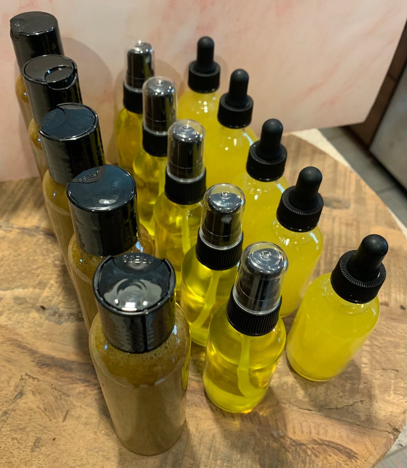 May include: A collection of 14 amber glass bottles with black caps and droppers. The bottles are filled with a yellow liquid. The bottles are arranged in a circular pattern on a wooden surface.
