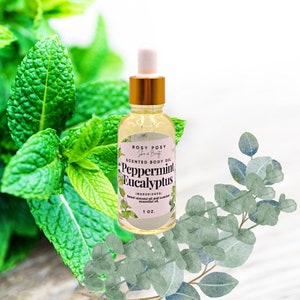 May include: A clear glass bottle with a gold lid and dropper filled with a yellow liquid. The bottle label reads "ROSY POSY Skin & Beauty SCENTED BODY OIL Peppermint Eucalyptus INGREDIENTS: Sweet almond oil and scented essential oil 1 OZ."
